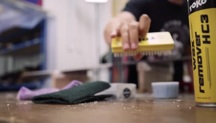 Structure the base with a structuring brush, firmly stroking from nose to tail across the whole board to create tiny grooves in the wax, reducing friction.