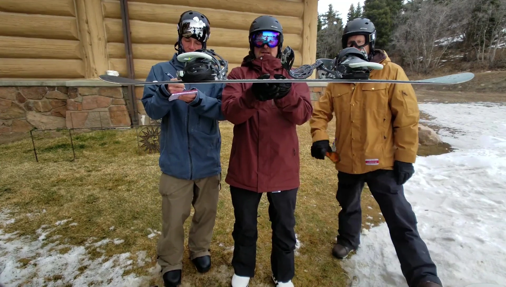 The snowboard laid flat on a table, highlighting its camber profile.