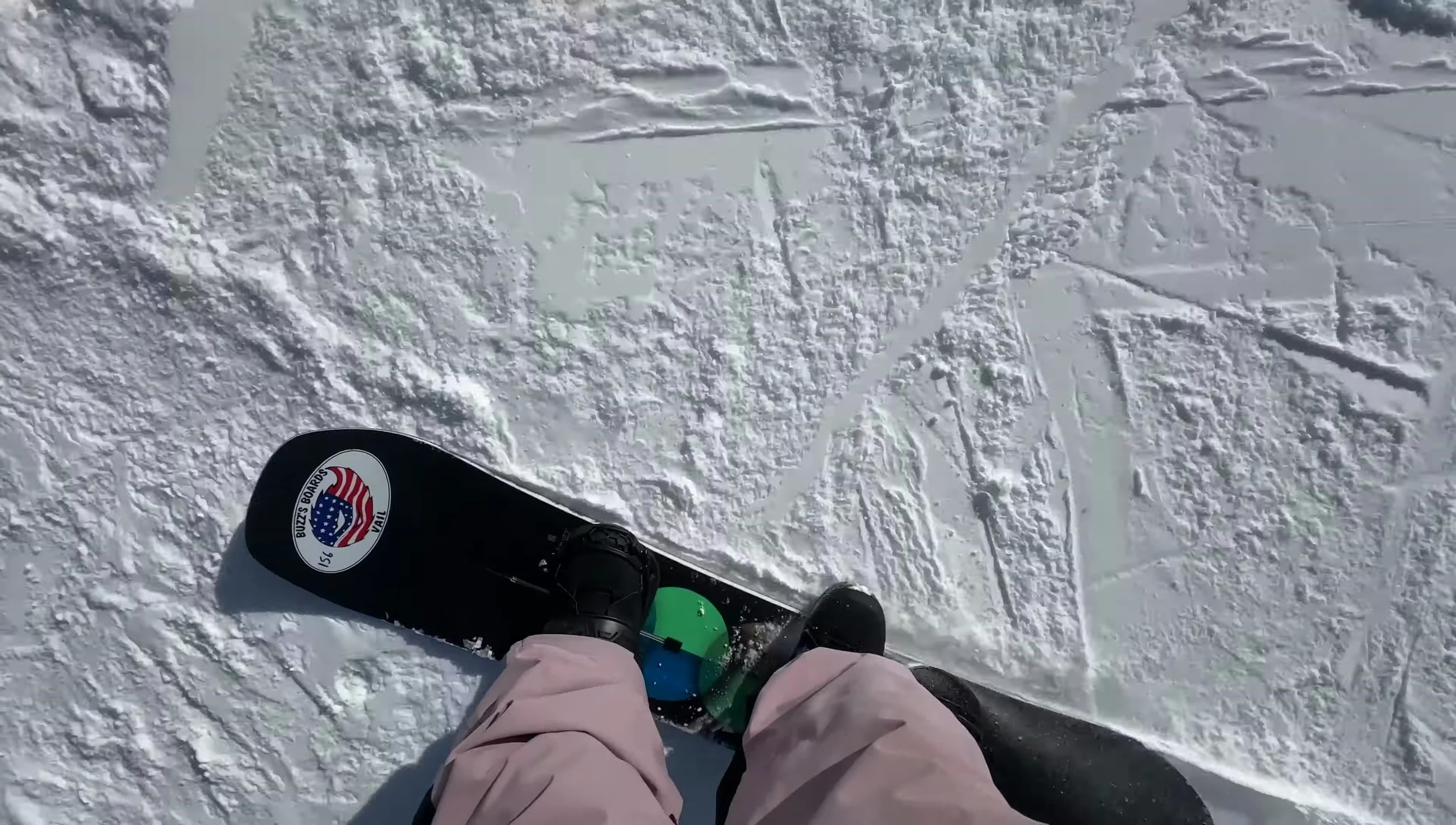 Close-up of the snowboard's full camber profile