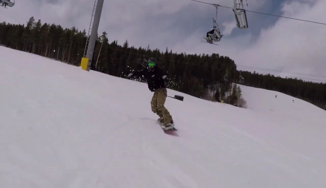 The snowboarder approaching a terrain park feature on the camber board.