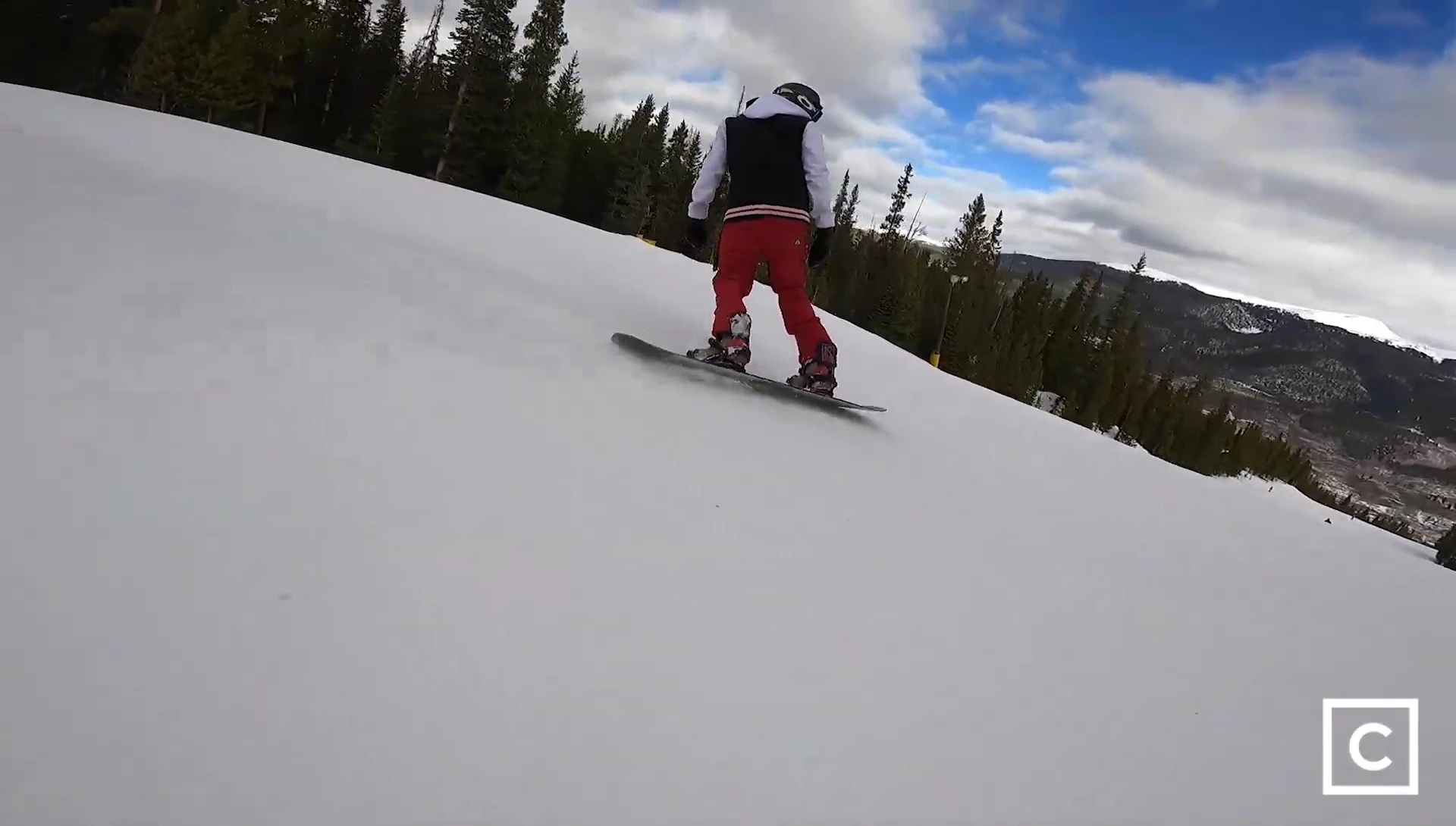 Rider carving a turn on hardpack snow, showcasing the board's power and control.