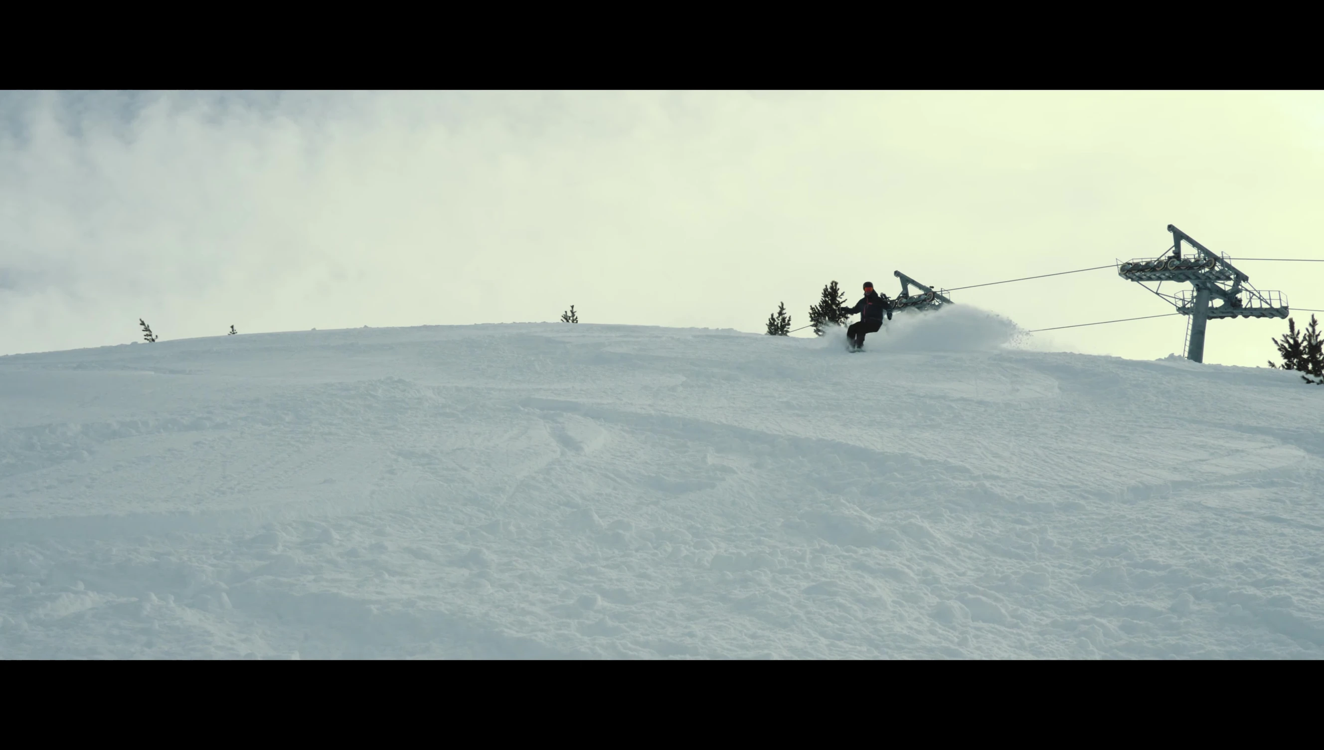 The snowboard floating through softer snow in the trees.