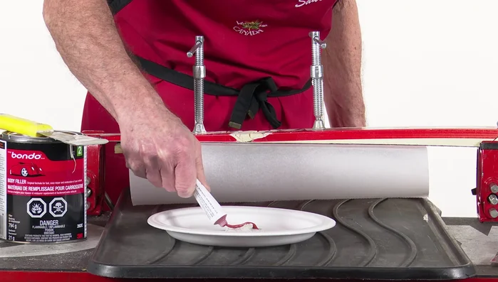 Use a petroleum jelly-coated steel scraper to further flatten and level the surface. Clamp and press down. Wait for curing.