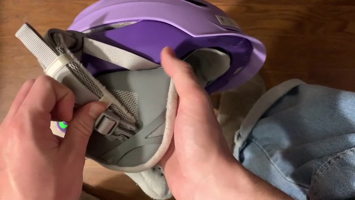 Slightly pull back the liner to expose the bow system (the mechanism that tightens the helmet).