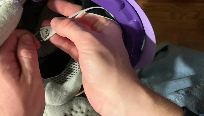 Pull the earpad from the front towards the brim of the helmet.