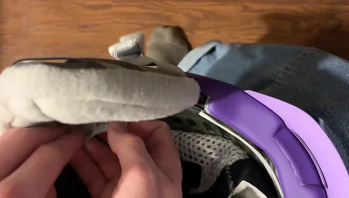 Pull the earpad from the front towards the brim of the helmet.