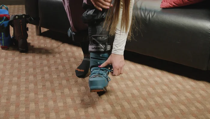 Go up on your tippy toes, thrust your knee forward, and use your thumb on the plastic piece while pulling the boot off your foot.