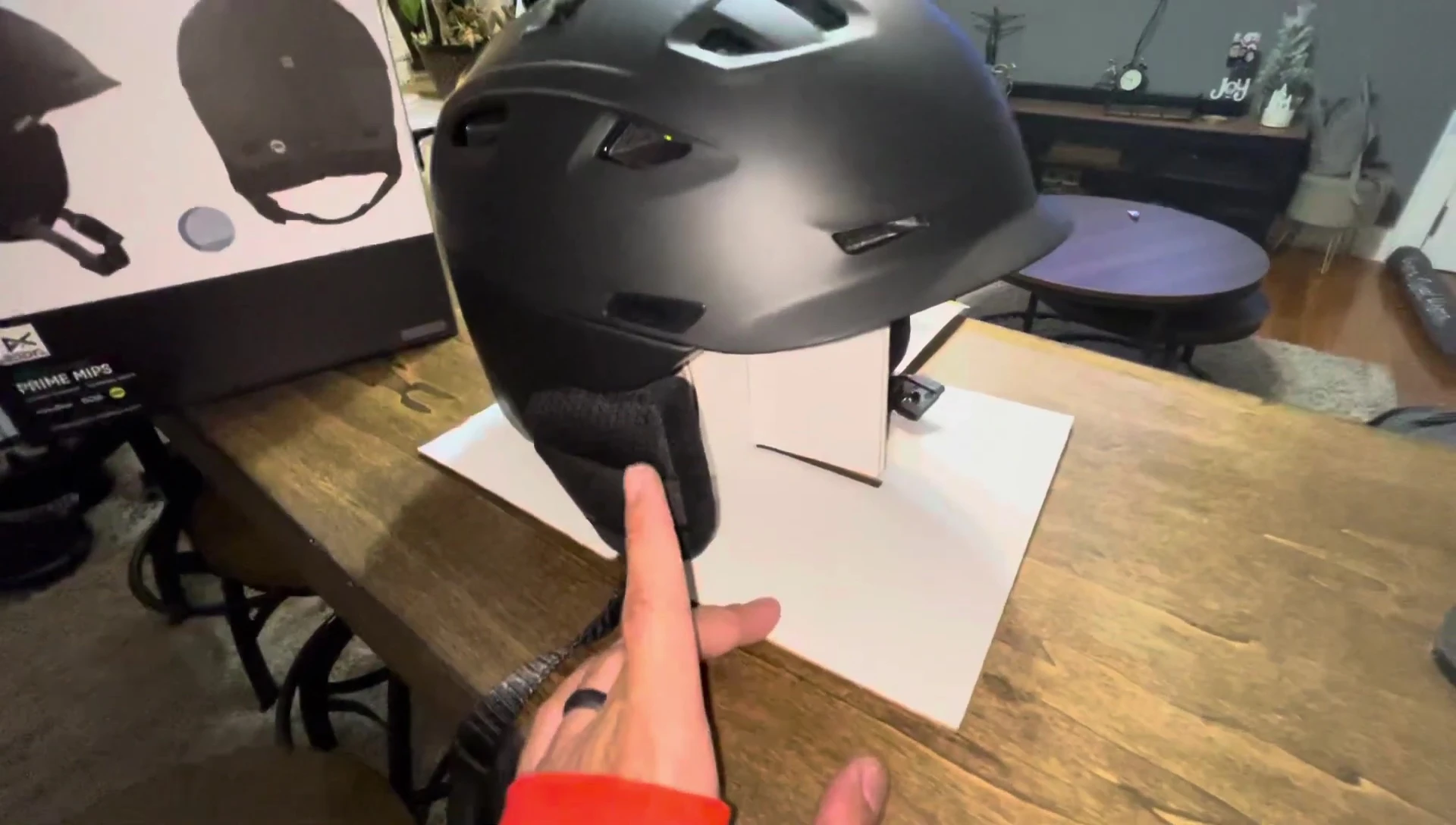 The reviewer highlighting the size of the helmet, comparing it to other brands.