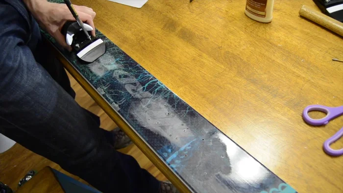 Insert the binding screws slightly into their holes, and then carefully screw them down until the binding is flush with the ski.