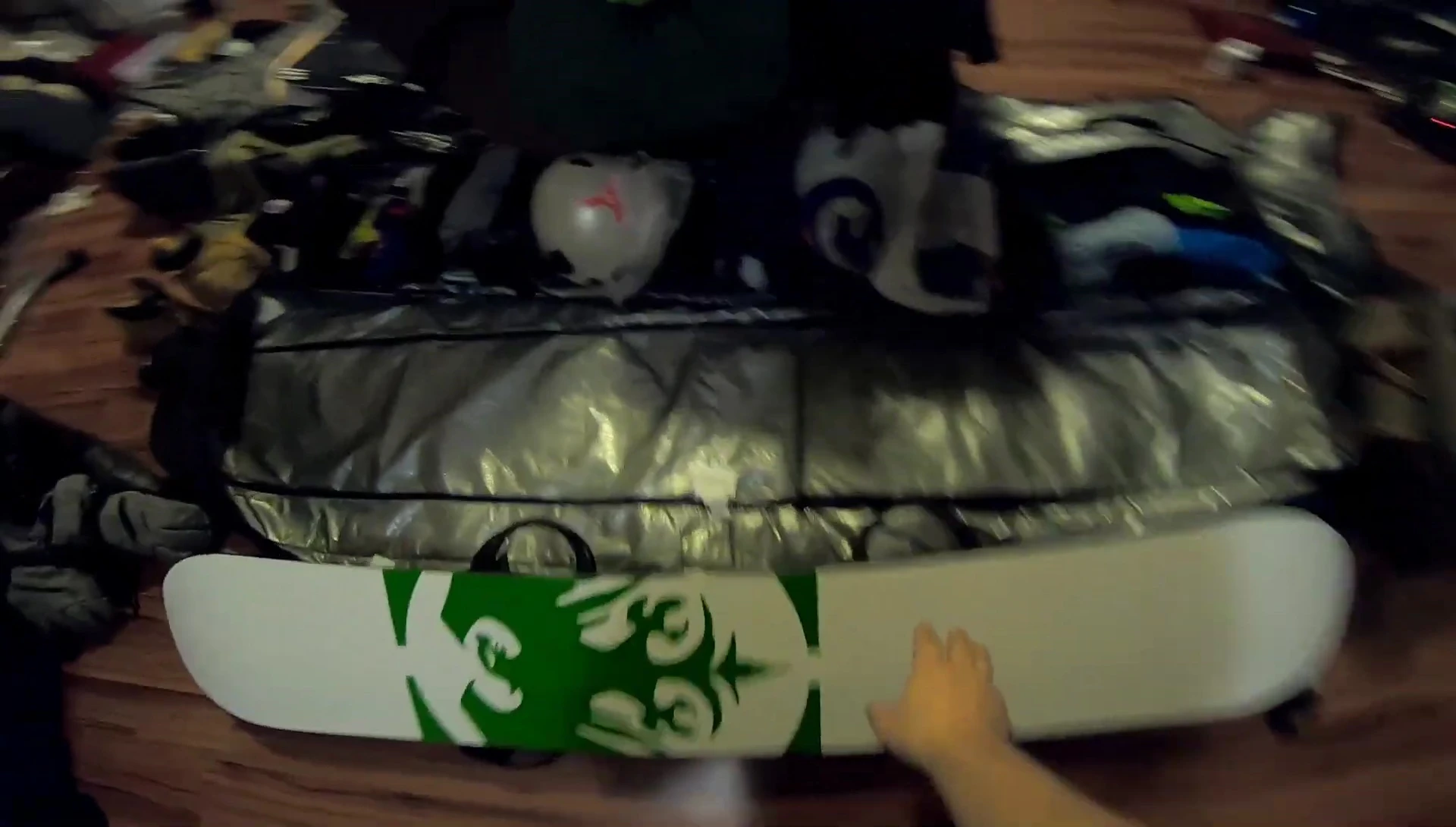 Snowboard placed at the bottom of the bag, ready for other items.