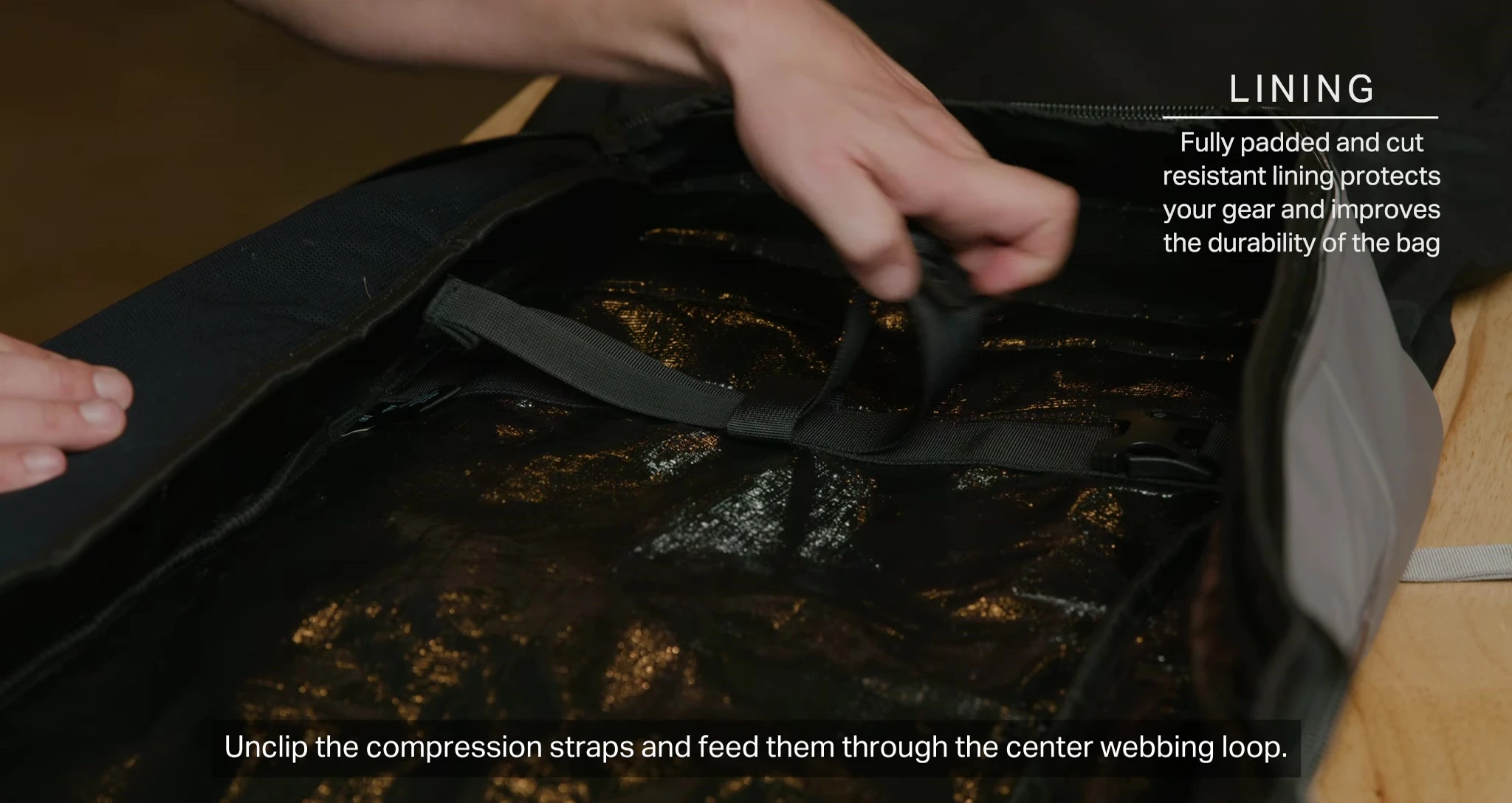 Unclipping and feeding the compression straps through the webbing loop.