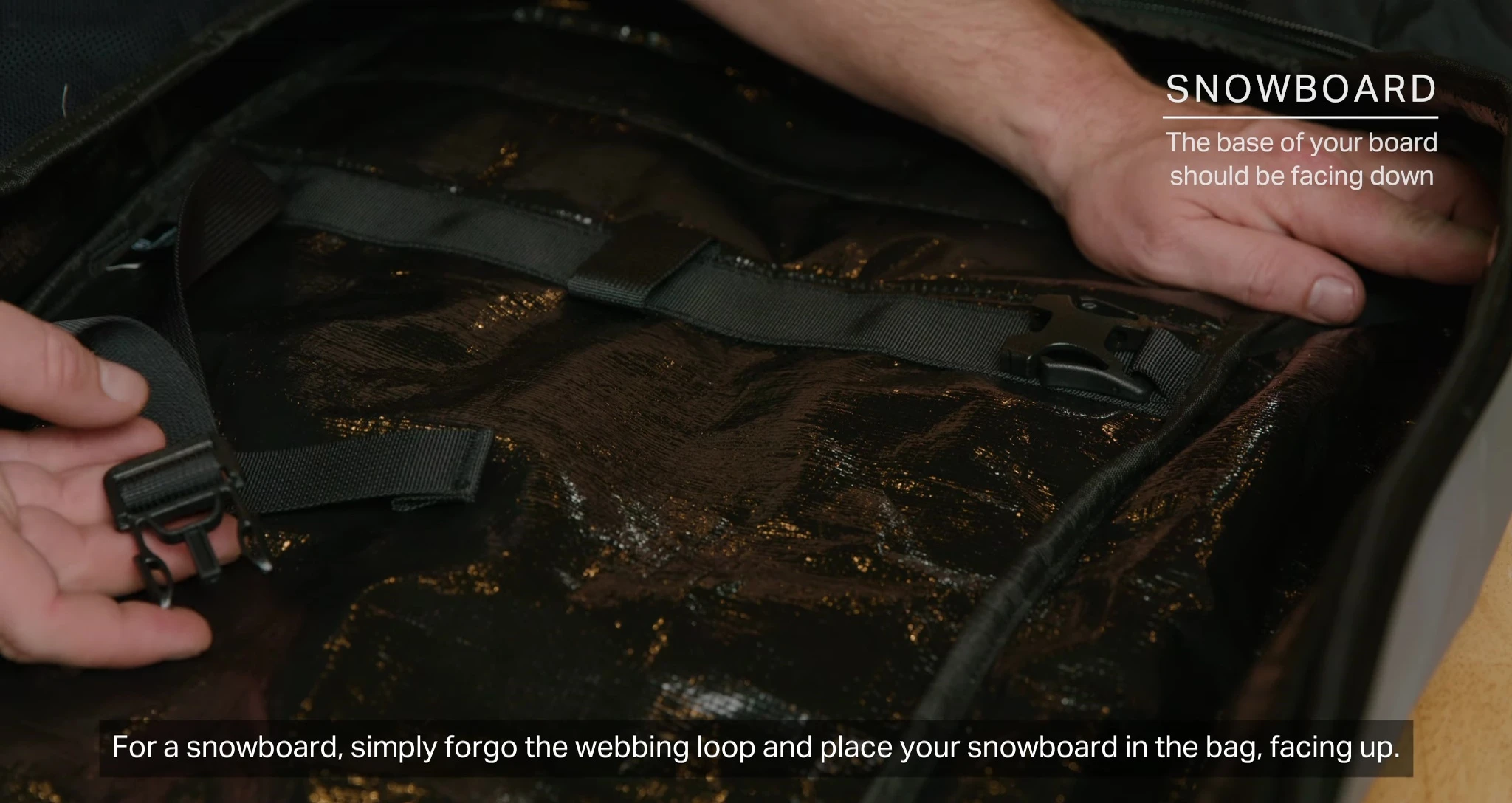 Placing a snowboard into the bag.
