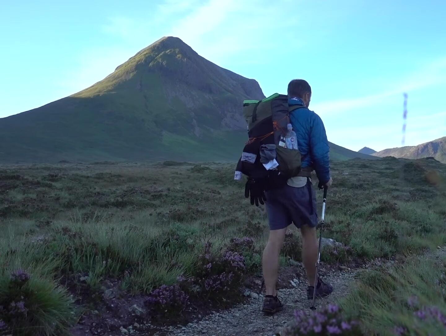 Image showing hiker using trekking poles to ascend a hill