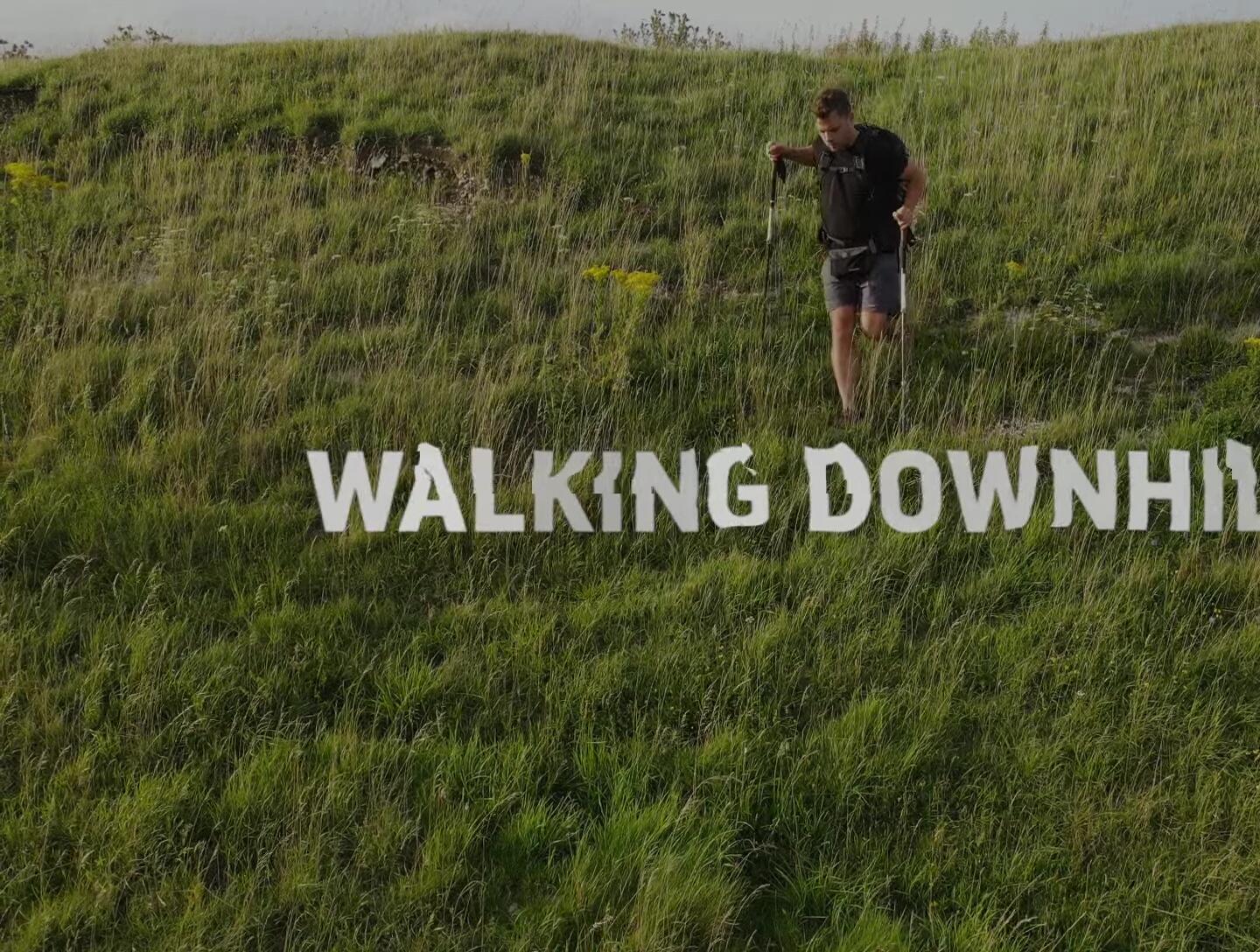 Hiker walking downhill, demonstrating downhill technique