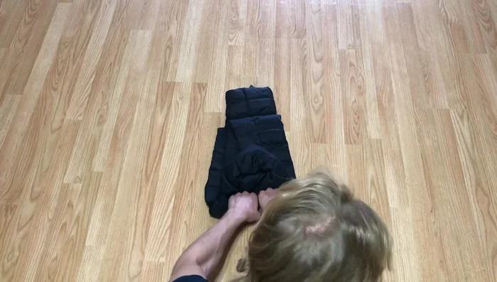 Use your hand to pull the cuff (from step 3) around the rolled coat, creating a 'coat burrito'.