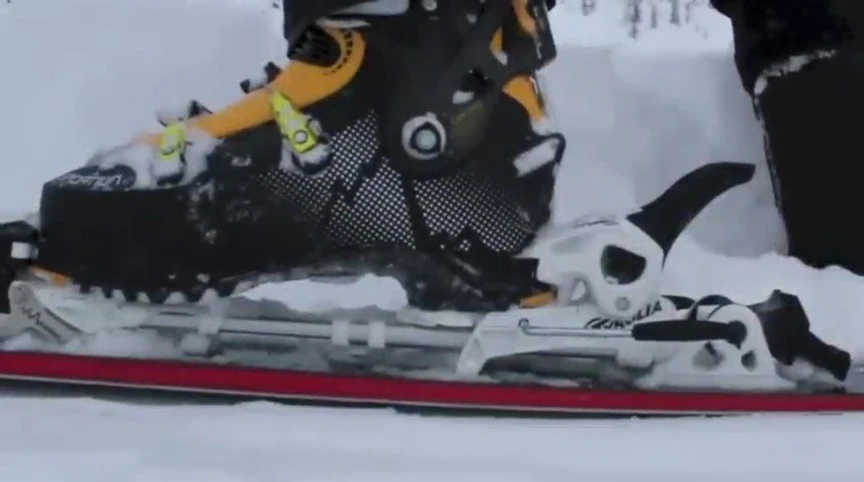 The speaker demonstrates the easy transition from ski to tour mode.