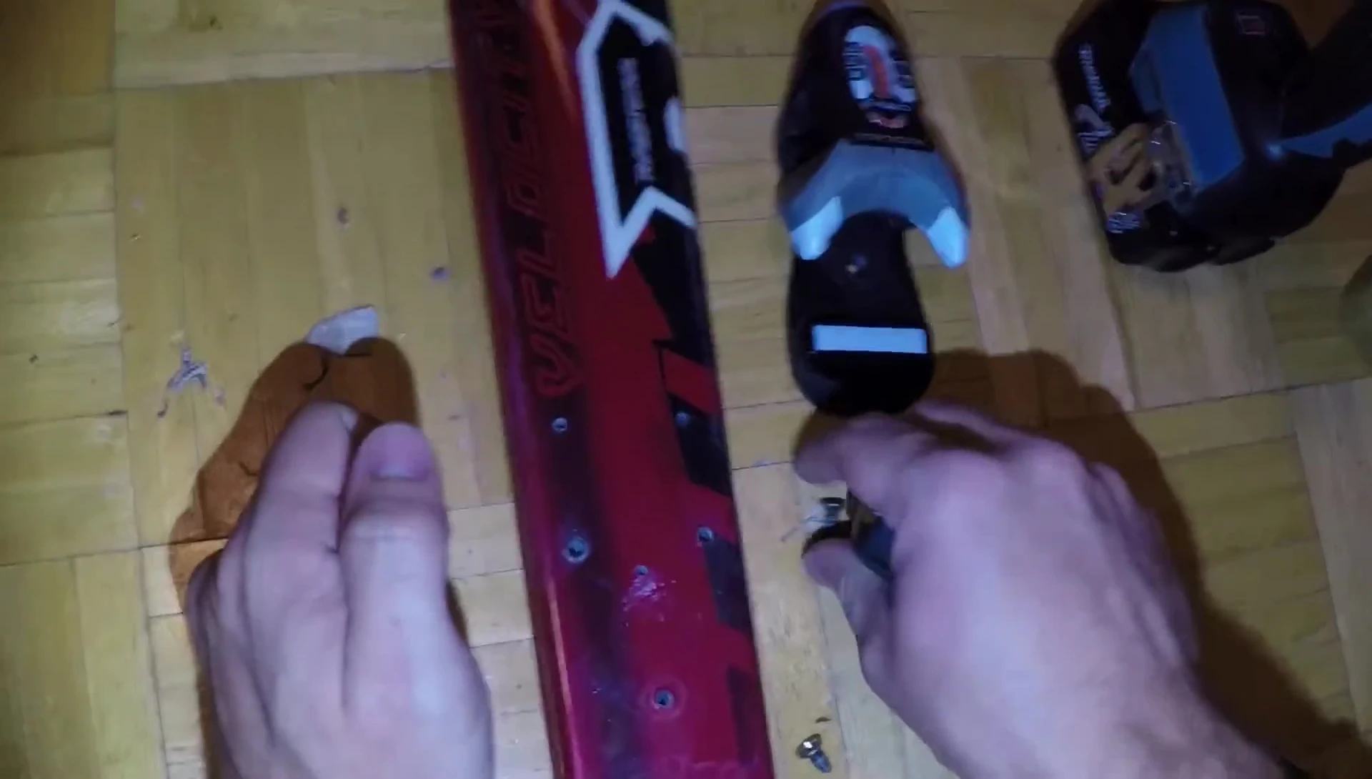 Hand-tightening the screws to install the new ski bindings.