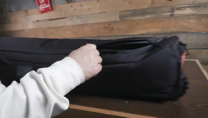 Demonstrates the ample space to accommodate a snowboard, bindings, boots, outerwear, and helmet.