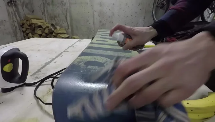 Apply wax to the entire base of the snowboard, focusing on the edges. Use an iron to melt and spread the wax evenly, keeping the iron moving to avoid overheating the base. Let it cool and dry for about 30 minutes until the wax is absorbed.