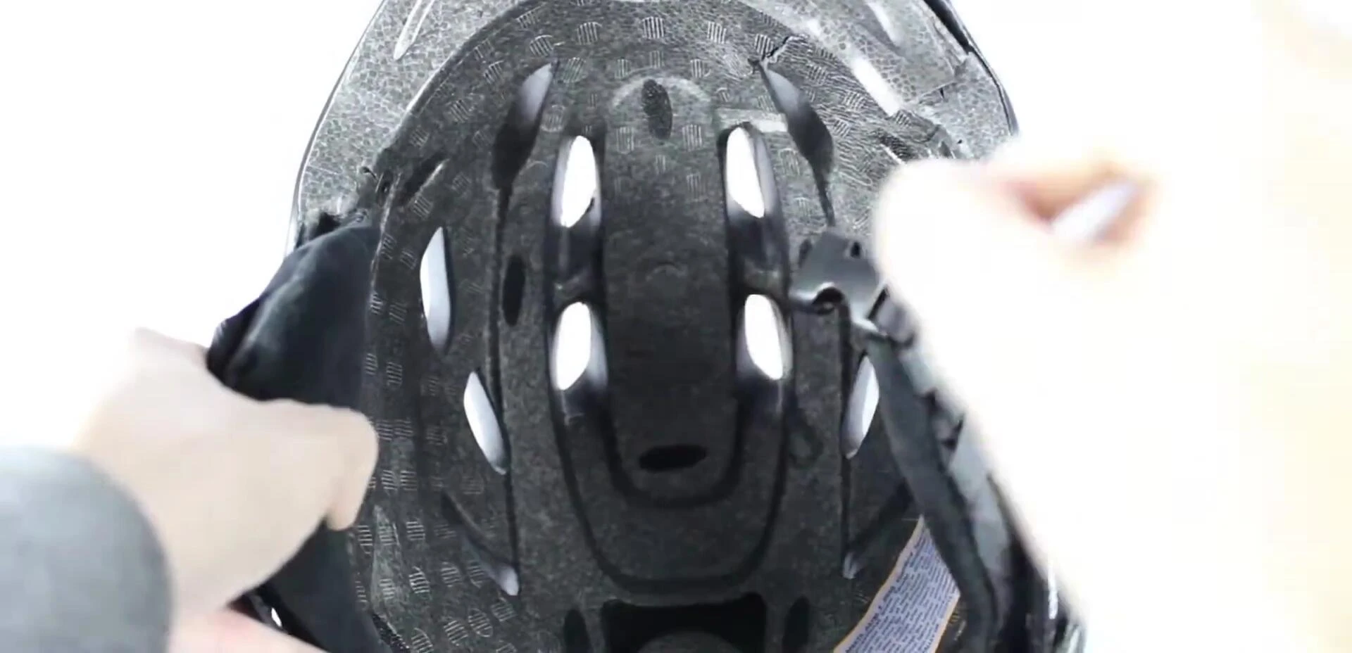 Person checking the buckle of a helmet