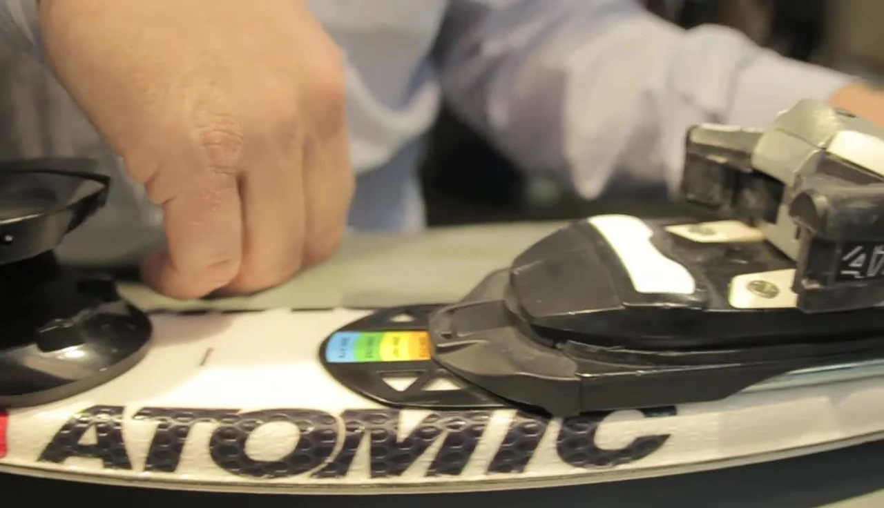 Person adjusting the toe piece lever.