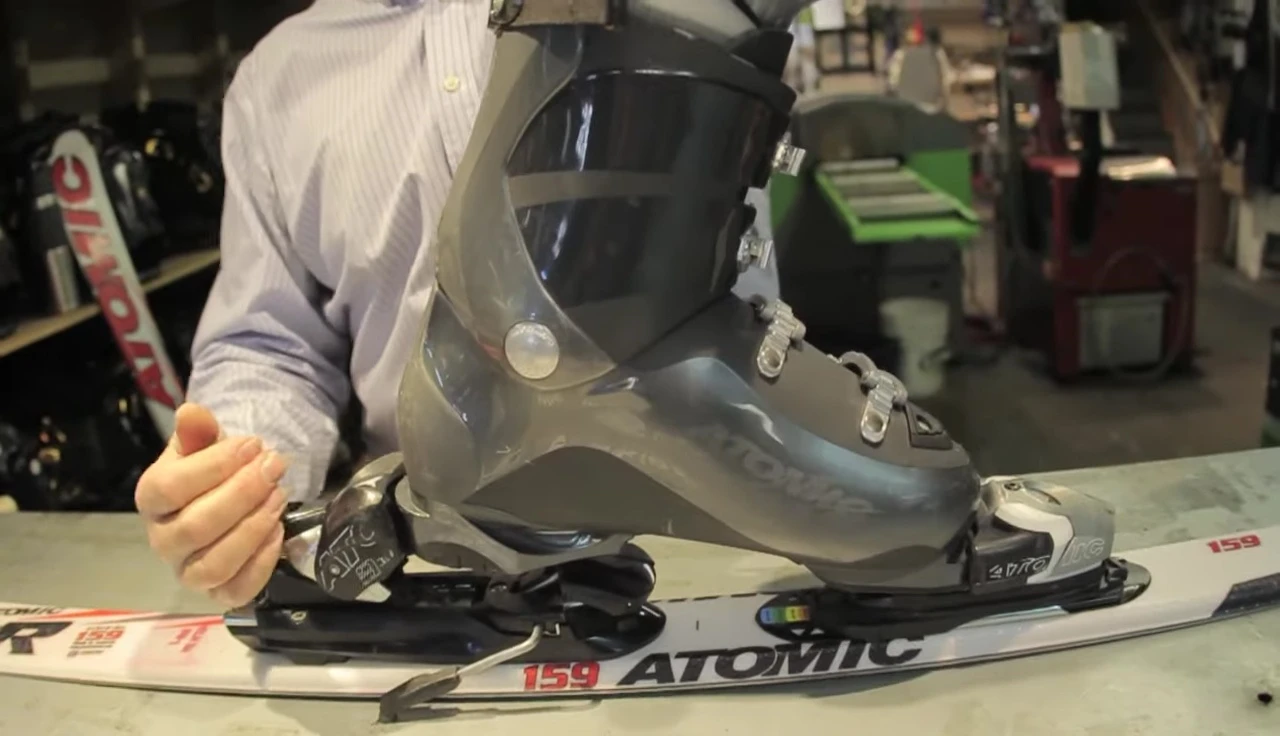 Pushing down on the boot to adjust the heel piece.
