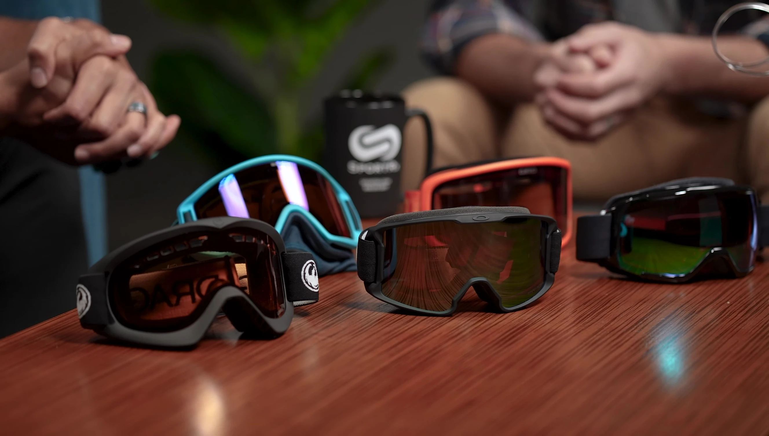 Various snow goggles laid out on a table.